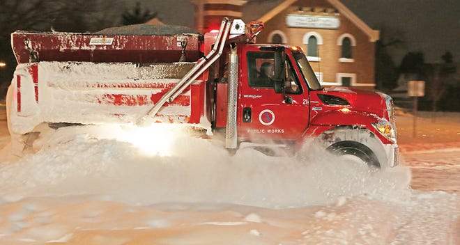 An Adrian city plow truck works in February to remove snowfall that accumulated on city streets.