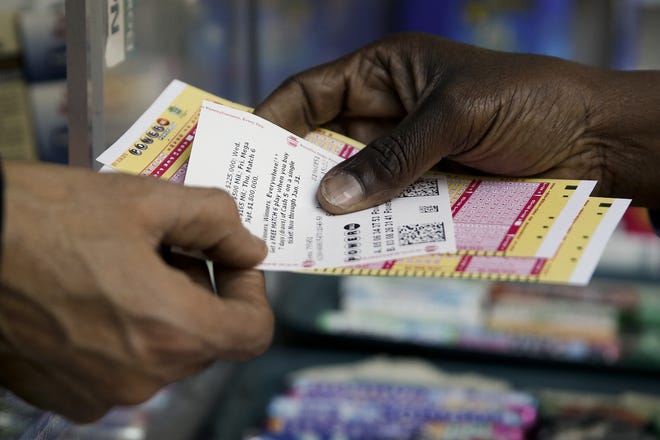 A person purchase Powerball lottery tickets from a newsstand Wednesday, Jan. 6, 2016, in Philadelphia. Players will have a chance Wednesday night at the biggest lottery prize in nearly a year. (AP Photo/Matt Rourke)