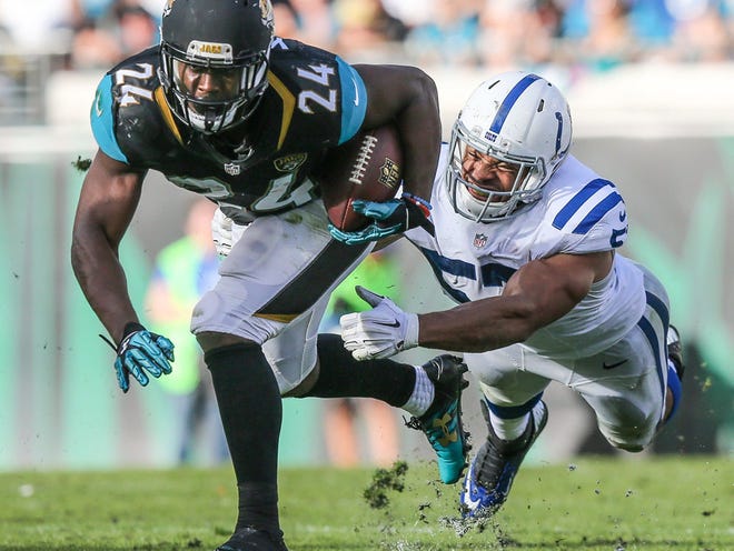Jacksonville Jaguars running back T.J. Yeldon (24) escapes a tackle by Indianapolis Colts inside linebacker Josh McNary (57) during the second half of NFL football action at EverBank Field in Jacksonville, Fla., Sunday, Dec. 13, 2015. Jacksonville won 51-16.