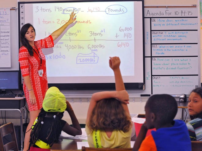 Fifth grade math and science teacher Mallory Browning goes over a conversion problem on her electronic whiteboard. Robert Curran is the math coach at Kings Trail Elementary in Jacksonville, FL. On Wednesday Oct. 14, 2015. Curran talked about the new DUVAL Math program, which is built from EngageNY/ Eureka Math program and worked with students in a 5th grade Math class.