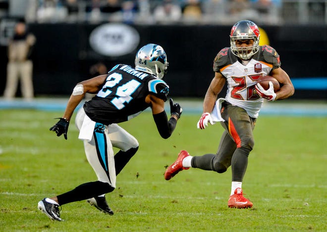 Tampa Bay Buccaneers running back Doug Martin (22) runs the ball as Carolina Panthers Josh Norman defends during the first half of a NFL football game against the Carolina Panthers in Charlotte, N.C. Sunday, Jan. 3, 2016. (AP Photo/Mike McCarn)