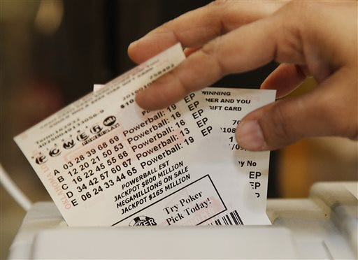 Momtaz Parvin pulls Powerball lottery tickets from the printer at her store in Oklahoma City on Friday, Jan. 8.