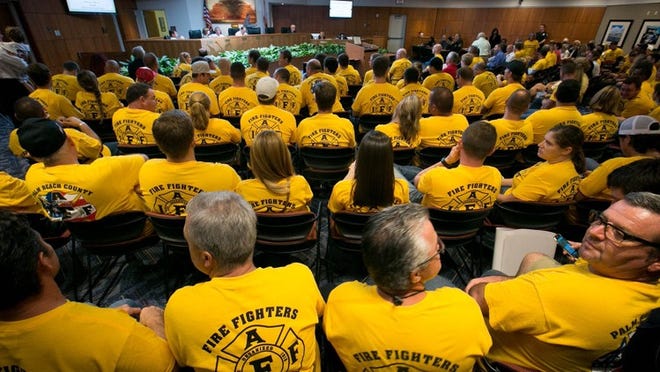 Firefighters and paramedics from Local 2928, IAFF filled the Palm Beach Gardens city council meeeting in Palm Beach Gardens, Florida on September 17, 2015. (Allen Eyestone / The Palm Beach Post)
