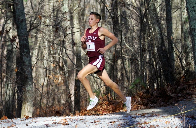 DJ Principe strides through the woods on his way to a first-place finish in the state cross-country championship.