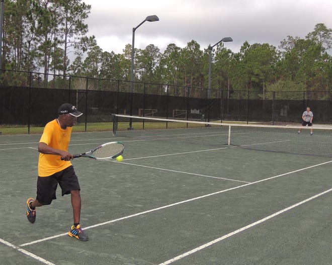 Aubrey Williams makes the save against tennis partner Phil Yansek at the Palm Coast Tennis Center open house event. NEWS-TRIBUNE PHOTOS/DANIELLE ANDERSON