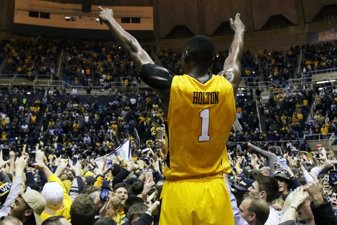 West Virginia forward Jonathan Holton (1) celebrates after his team defeated Kansas in an NCAA college basketball game, Tuesday, Jan, 12, 2016, in Morgantown, W.Va. West Virginia defeated Kansas 74-63. (AP Photo/Raymond Thompson)