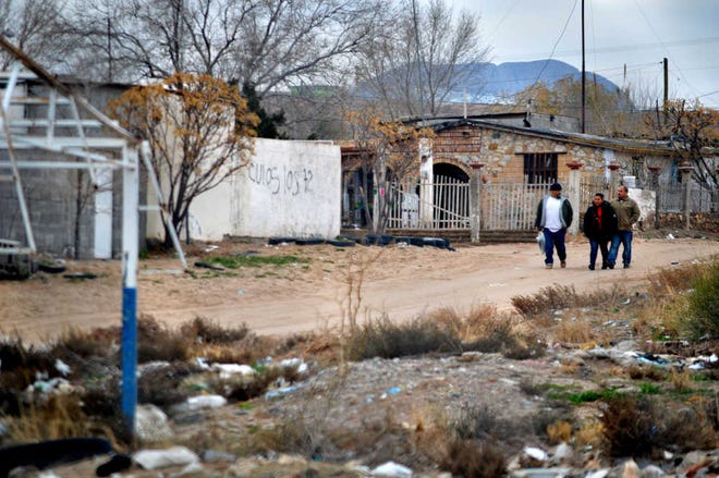 In this photo taken Jan. 4, 2016, a group of people walk in a Juarez, Mexico, neighborhood across the border from Sunland Park, N.M. Officials in nearby El Paso, Texas, and Juarez, Mexico, are preparing for a Pope Francis visit to the Mexican city next month. Juarez, on Mexico's northern border across from El Paso, is the last stop in the Pope's schedule 5-day trip to Mexico between Feb. 12-17. (AP Photo/Russell Contreras)