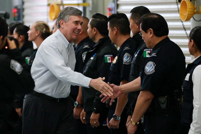 U.S. Customs and Border Protection Commissioner R. Gil Kerlikowske, left, shakes hands with Mexican customs officials during an inauguration ceremony for a new border truck inspection station built for both Mexican and U.S. customs Tuesday, Jan. 12, 2016, in Tijuana, Mexico. The joint inspection facility just blocks from one of the busiest crossings on the nearly 2,000-mile border is designed to allow customs agents from both countries inspecting trucks entering the United States simultaneously. (AP Photo/Gregory Bull)
