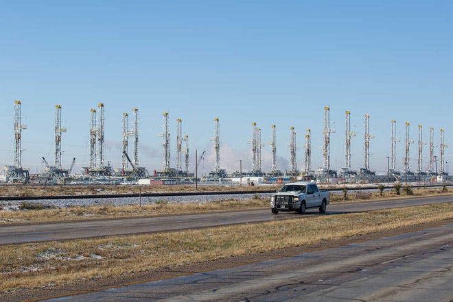 FILE - In this Wednesday, Feb. 25, 2015, file photo, more than 30 oil drilling rigs are idle in a Helmerich & Payne, Inc. yard in Odessa, Texas, along Highway 80, as rig counts drop in the Permian Basin. The price of oil continues to fall, extending a slide that has already gone further and lasted longer than most thought, and probing depths not seen since 2003. Lower crude prices are leading to lower prices for gasoline, diesel, jet fuel and heating oil, giving drivers, shippers, and many businesses a big break on fuel costs. But layoffs across the oil industry are mounting, and bankruptcies among oil companies are expected to soar. (Courtney Sacco/Odessa American via AP) MANDATORY CREDIT