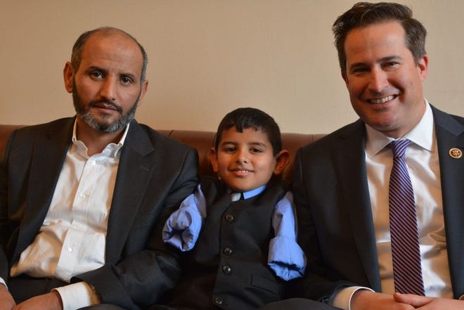 Ahmad Alkhalaf, 9, sits with his father, Dirgam, left, and Rep. Seth Moulton, D-Salem. Ahmad is a Syrian refugee who was severely injured in a bombing. He and his dad live in Sharon