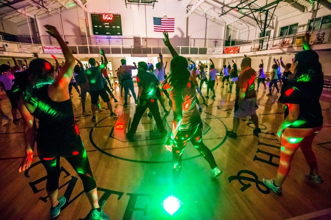 Participants sweating with the disco lights, at a Blacklight Zumba party in the gym at the Hyannis Youth and Community Center last Friday night. PHOTO BY ALAN BELANICH