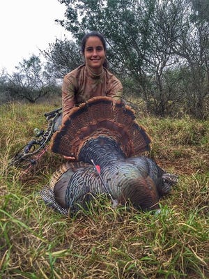 Rachel Staples shows off a Rio Grande turkey she shot with a bow on a recent hunting trip to Texas.
