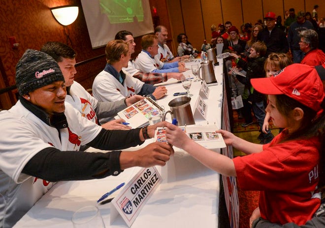 St. Louis Cardinals pitcher Carlos Martinez hands autographed cards to Maddie Feagin of Tremont during the Cardinals Caravan event at Embassy Suites Convention Center in East Peoria on Friday.