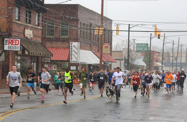 Participants in the Run for the River 5K, an addition to the annual race that began with an 8K, make their way down Herritage Street in Kinston during a steady shower in March 2014.