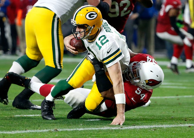 In this Dec. 27, 2015, file photo, Green Bay Packers quarterback Aaron Rodgers (12) is sacked by Arizona Cardinals inside linebacker Dwight Freeney during the second half of an NFL football game, in Glendale, Ariz. Three weeks ago, the Arizona Cardinals beat the Green Bay Packers by 30 points. No one should expect that kind of blowout when the teams meet again Saturday night, this time in the NFC divisional playoffs.