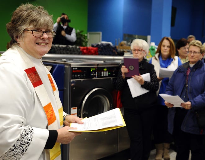 Urban Missioner Rev. Meredyth Wessman Ward looks out at her friends during the celebration of her new ministry at Suds Up Laundromat on Thursday. T&G Staff/Christine Hochkeppel