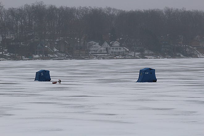 Ice fishing enthusiasts and their portable shanties are seen Friday morning at the north end of Devils Lake. Approximately four inches of ice had formed by Friday on the 1,300-acre lake, one inch less than recommended for fishing. Warmer temperatures have prevented a strong amount of ice from forming so far this winter.
