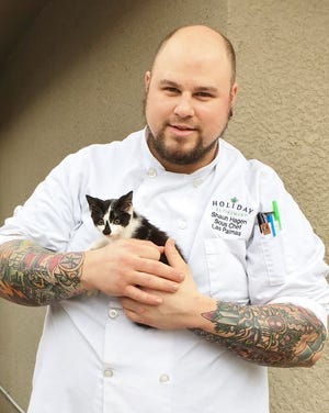 Shaun Hagen, a sous chef at Las Palmas Retirement Community in Palm Coast, fed and cared for a kitten that strayed away from its adopted family until the owners were located. PHOTO PROVIDED/ELIZABETH ROBINSON