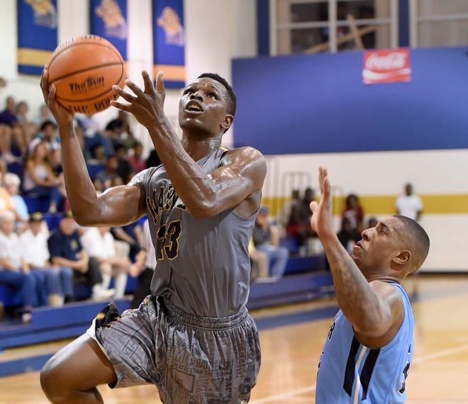 Warner junior guard Warren Hall, left, goes up for a basket against Keiser's Stanley Whittaker on Saturday at the Turner Athletic Center in Lake Wales. Hall led the Royals in a loss with 18 points.