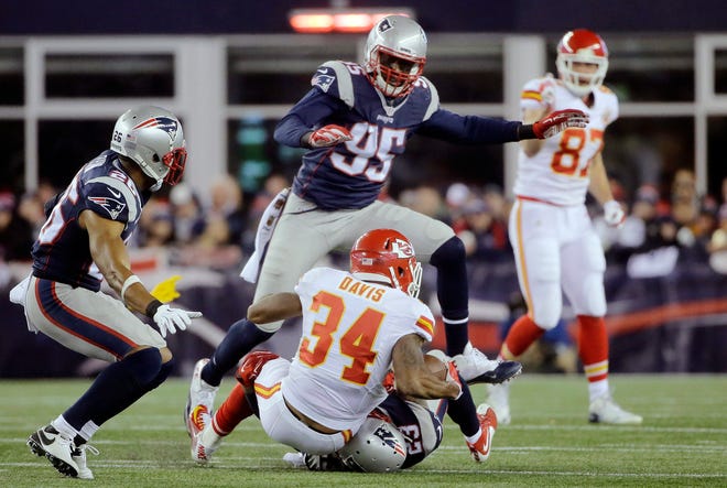 Patriots defensive end Chandler Jones (95) hurdles Kansas City Chiefs running back Knile Davis (34) as he is tackled by safety Patrick Chung during the second half on Saturday. AP Photo
