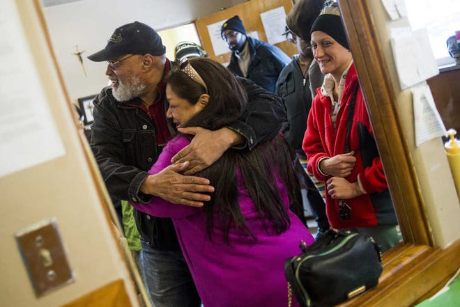 Pastor Bobby Jackson hugs Flint, Mich., resident Joanne Diaz as she picks up cases of free bottled water Saturday, Jan. 16, 2016, at Mission of Hope on Flint's north side. (Jake May/The Flint Journal-MLive.com via AP)