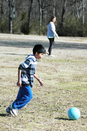 STEVE MARQUEZ • TIMES RECORD Christian Cartagena, 9, kicks a soccer ball while Lydia Bush looks on at Ben Geren Regional Park on Friday, Jan. 15, 2016. Cartagena was kicking the ball with Bush and another boy whom Lydia was babysitting. Christian was also in the park with his sisters and dad, Juan, as temperatures were in the upper 50s. Temperatures are forecast to be lower today with a high near 45.