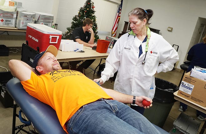 Ben Fox of Blissfield is prepped for a blood donation by Brenda Marshall of the American Red Cross during a blood drive Dec. 31 at the Riga Township Fire 
Department.