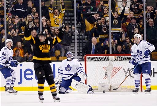 Toronto Maple Leafs' Jonathan Bernier (45) kneels beside the net as Boston Bruins' Patrice Bergeron, foreground, celebrates a goal by Brad Marchand during the third period of an NHL hockey game in Boston, Saturday, Jan. 16, 2016. The Bruins won 3-2. (AP Photo/Michael Dwyer)