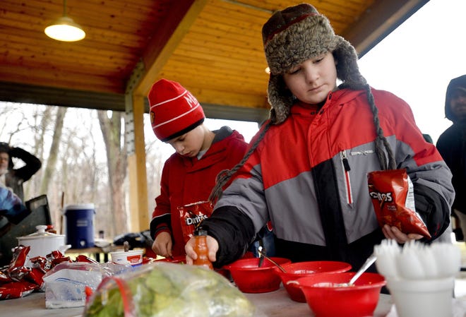 Mark Recker, 9, of Millcreek Township, left, and James Kuntz, 9 of Millcreek Township, both Webelos from Pack 182, make "walking tacos" Jan. 16 at a food workshop during Webelo's Woods, an event run by boy scouts to build relationships between older and younger scouts. "Walking tacos" is a term for tacos made in a bag in order to be more portable for eating on the go. The event was held at Presque Isle State Park. SARAH CROSBY/