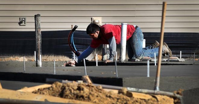 (John Clark/The Gazette) A worker does concrete work at one of the Eastwood Homes sites in The Village at Parkside development off Forbes Road in Gastonia. City records show the local housing construction total is steadily approaching pre-recession levels.