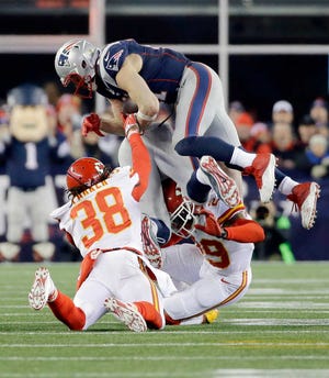 New England Patriots wide receiver Julian Edelman (11) is tackled by Kansas City Chiefs strong safety Ron Parker (38) and Eric Berry (29) in the second half of an NFL divisional playoff football game, Saturday, Jan. 16, 2016, in Foxborough, Mass. (AP Photo/Elise Amendola)
