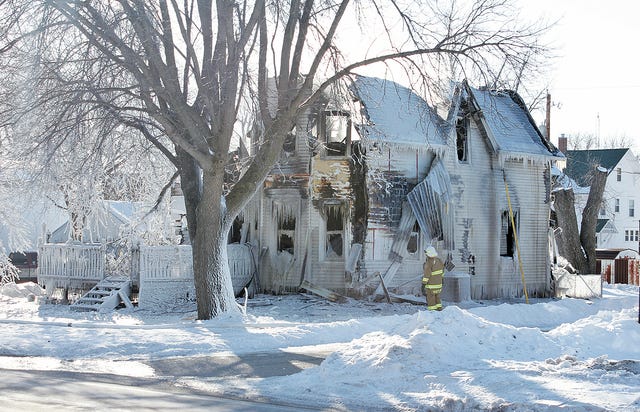 Sunday afternoon, firefighters were still on scene of a house fire that occurred shortly before 1 a.m. Sunday in Boxholm. The fire claimed the lives of a mother and her three young children. Photo by Whitney Sager/Boone News-Republican