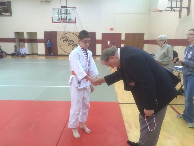 Sam Mason of the Canton Family YMCA Judo Team receives a silver medal in the junior boys' division at the Hollis Park Invitational Judo Tournament.