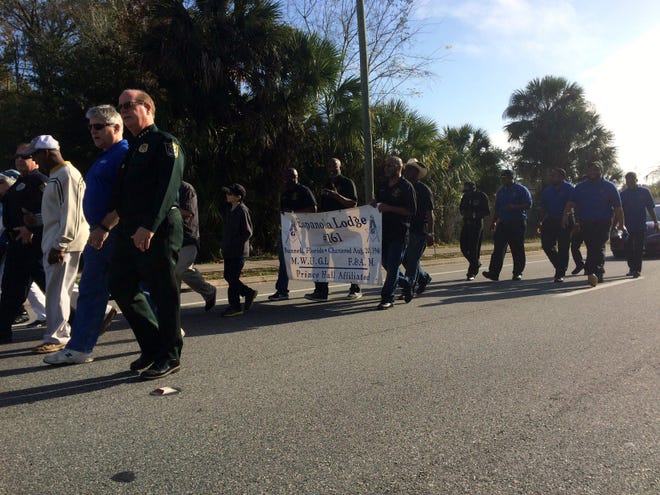 City and county officials join members of several community organizations in a march down U.S. 1 in Bunnell on Saturday in honor of Dr. Martin Luther King Jr.'s birthday. NEWS-TRIBUNE/PATRICK GROVES