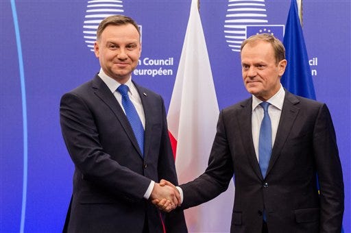 European Council President Donald Tusk, right, welcomes Polish President Andrzej Duda upon his arrival at the EU Council in Brussels on Monday, Jan. 18, 2016. (AP Photo/Geert Vanden Wijngaert)