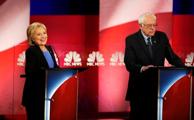 Democratic presidential candidate, Hillary Clinton, left, smiles during the NBC, YouTube Democratic presidential debate at the Gaillard Center, Sunday, Jan. 17, 2016, in Charleston, S.C. To the right is Democratic presidential candidate, Sen. Bernie Sanders, I-Vt.(AP Photo/Stephen B. Morton)