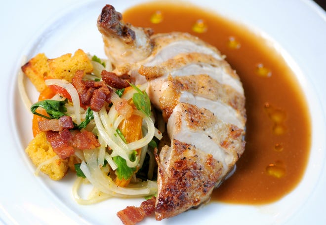 District Kitchen & Cocktails serves an airline chicken breast with a deeply reduced sauce and salad of cornbread, sweet onions and roasted peppers. Paul Stephen/StarNews