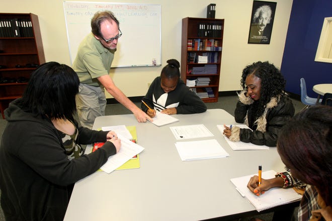 Professor Timothy O'Rawe works recently with some students at Catapult Learning Academy in Daytona Beach. The program is designed to help recent dropouts get their high school degrees, with many of them going on to college. News-Journal/LOLA GOMEZ