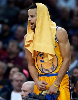Golden State Warriors"™ Stephen Curry cheers on his team from the bench in the first half of an NBA basketball game against the Cleveland Cavaliers, Monday, Jan. 18, 2016, in Cleveland. The Warriors won 132-98. (AP Photo/Tony Dejak)