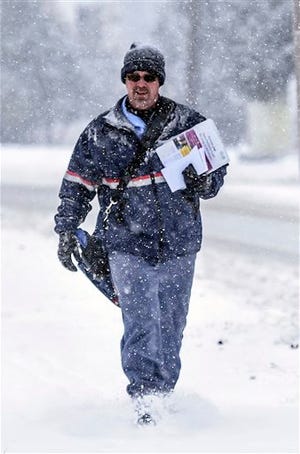 United States Post Office employee Todd Smith delivers the mail Wednesday, Jan. 20, 2016, in Danville, Ky. Snow and drizzle began falling early Wednesday across much of Kentucky and Tennessee leading school districts and some universities to cancel classes and officials to warn motorists to drive carefully. (Clay Jackson/The Advocate-Messenger via AP) TABLOIDS OUT; MANDATORY CREDIT