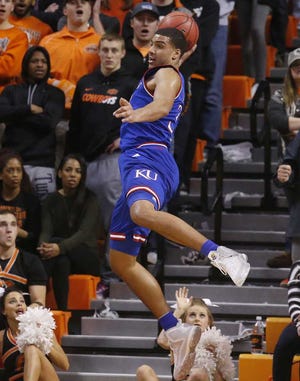 Kansas forward Landen Lucas keeps the ball in bounds in the first half of an NCAA college basketball game against Oklahoma State in Stillwater, Okla., Tuesday, Jan. 19, 2016. (AP Photo/Sue Ogrocki)