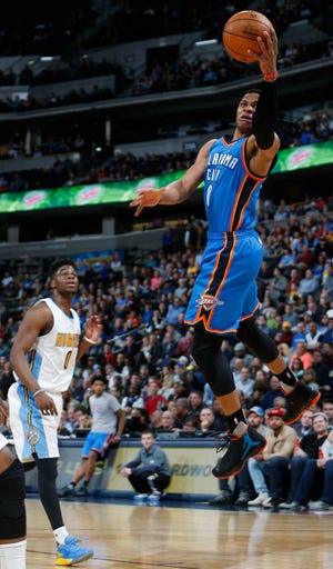 Oklahoma City Thunder guard Russell Westbrook, left, goes up for a shot after driving past Denver Nuggets guard Emmanuel Mudiay in the first half of an NBA basketball game Tuesday, Jan. 19, 2016, in Denver. (AP Photo/David Zalubowski)