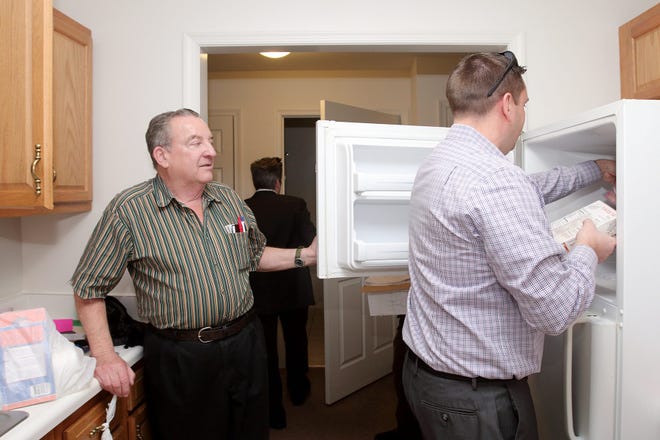 Former homeless veteran Barry Long, left,and Orange County Executive Steve Neuhaus put away groceries in Long's new apartment in Port Jervis on Wednesday. DAWN J. BENKO/For the Times Herald-Record