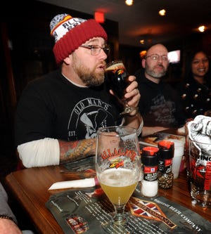 Bob Walker tastes beer during a beer club meeting at British Beer Company in Hyannis. RON SCHLOERB/CAPE COD TIMES