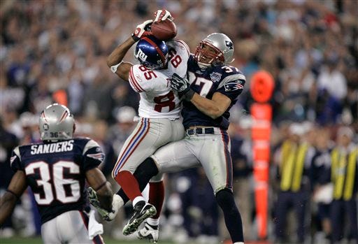 FILE - In this Feb. 3, 2008, file photo, New York Giants receiver David Tyree (85) catches a 32-yard pass in the clutches of New England Patriots safety Rodney Harrison (37) during the fourth quarter of NFL football's Super Bowl XLII in Glendale, Ariz. The Giants won 17-14. (AP Photo/Gene Puskar, File)