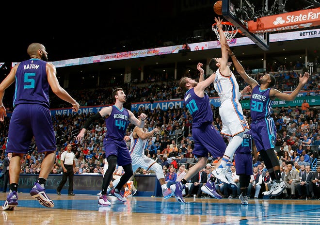 Oklahoma City's Enes Kanter (11) puts up a shot between Charlotte's Spencer Hawes (00) and Troy Daniels (30) during an NBA basketball game between the Oklahoma City Thunder and the Charlotte Hornets at Chesapeake Energy Arena, Wednesday, Jan. 20, 2016. Photo by Bryan Terry, The Oklahoman
