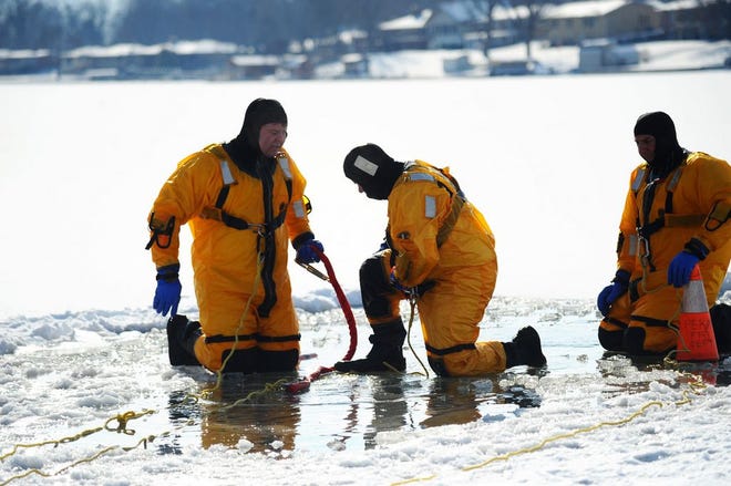 Pekin Fire Department firefighters Josh Rademaker, Trent Reeise and Steve Bresnahan go through a series of training exercises at Lake Arlan Thursday. The training was designed to prepare firefighters for rescue operations for people who have fallen through ice.