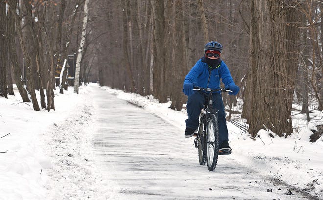 On Jan. 21, Jay Good bicycles along the snow-covered multi-purpose trail at Presque Isle State Park. "I ride about 40 miles a day in the summer and about 25 in the winter," said Good, 36, of Millcreek Township. CHRISTOPHER MILLETTE/