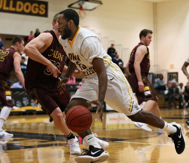Adrian College sophomore Anthony Cannon drives against Calvin College sophomore Mike Siegel Saturday during their game at the Merillat Sport and Fitness Center. The Bulldogs won 85-61.
