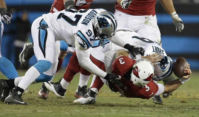 Arizona Cardinals' Carson Palmer fumbles as he is hit by Carolina Panthers' Kawann Short and Mario Addison (97) during the first half the NFL football NFC Championship game Sunday in Charlotte, N.C. Associated Press/Bob Leverone